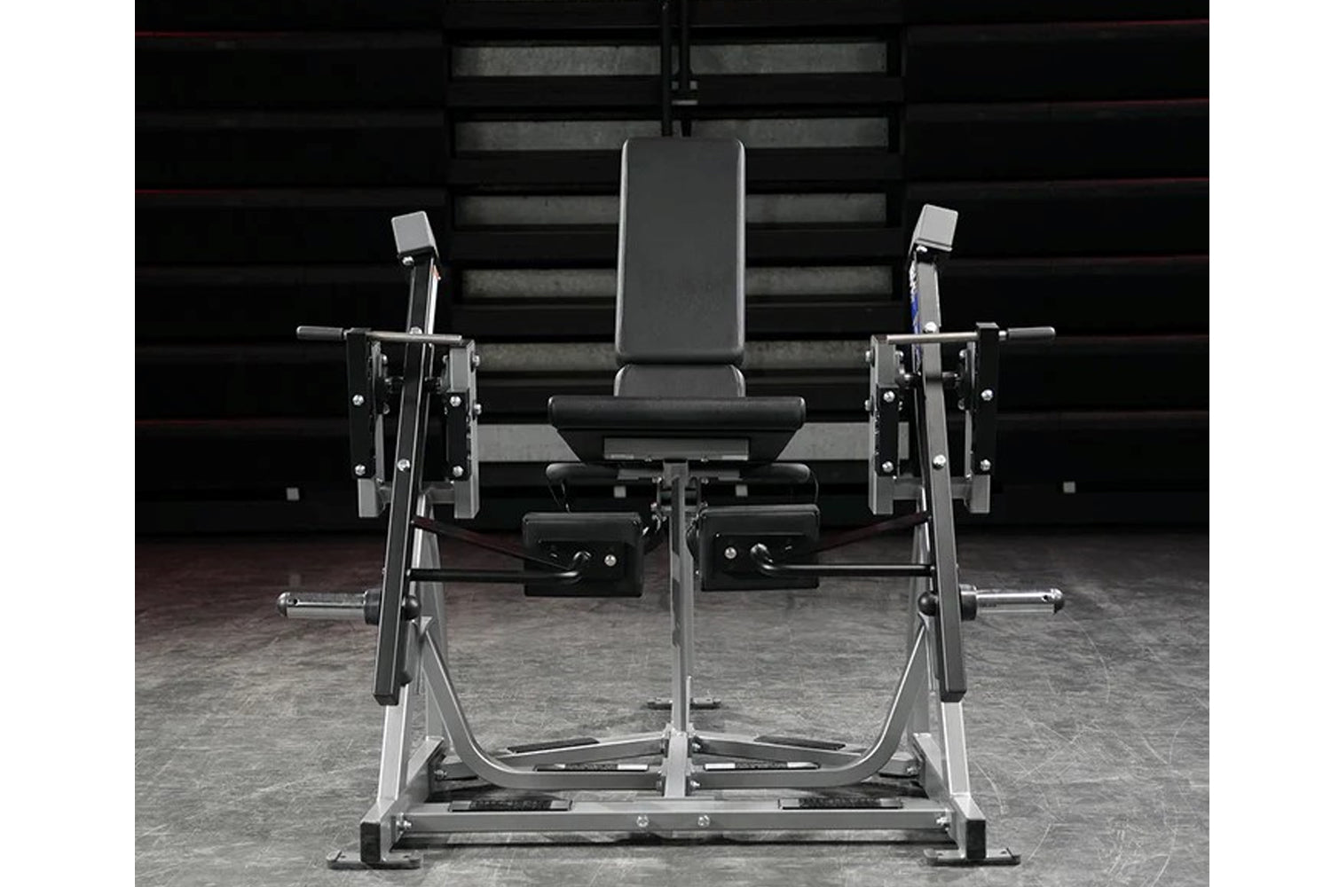 Hammer Strength plate-loaded iso-lateral leg extension machine with black padded seat and silver frame, front view on gym flo