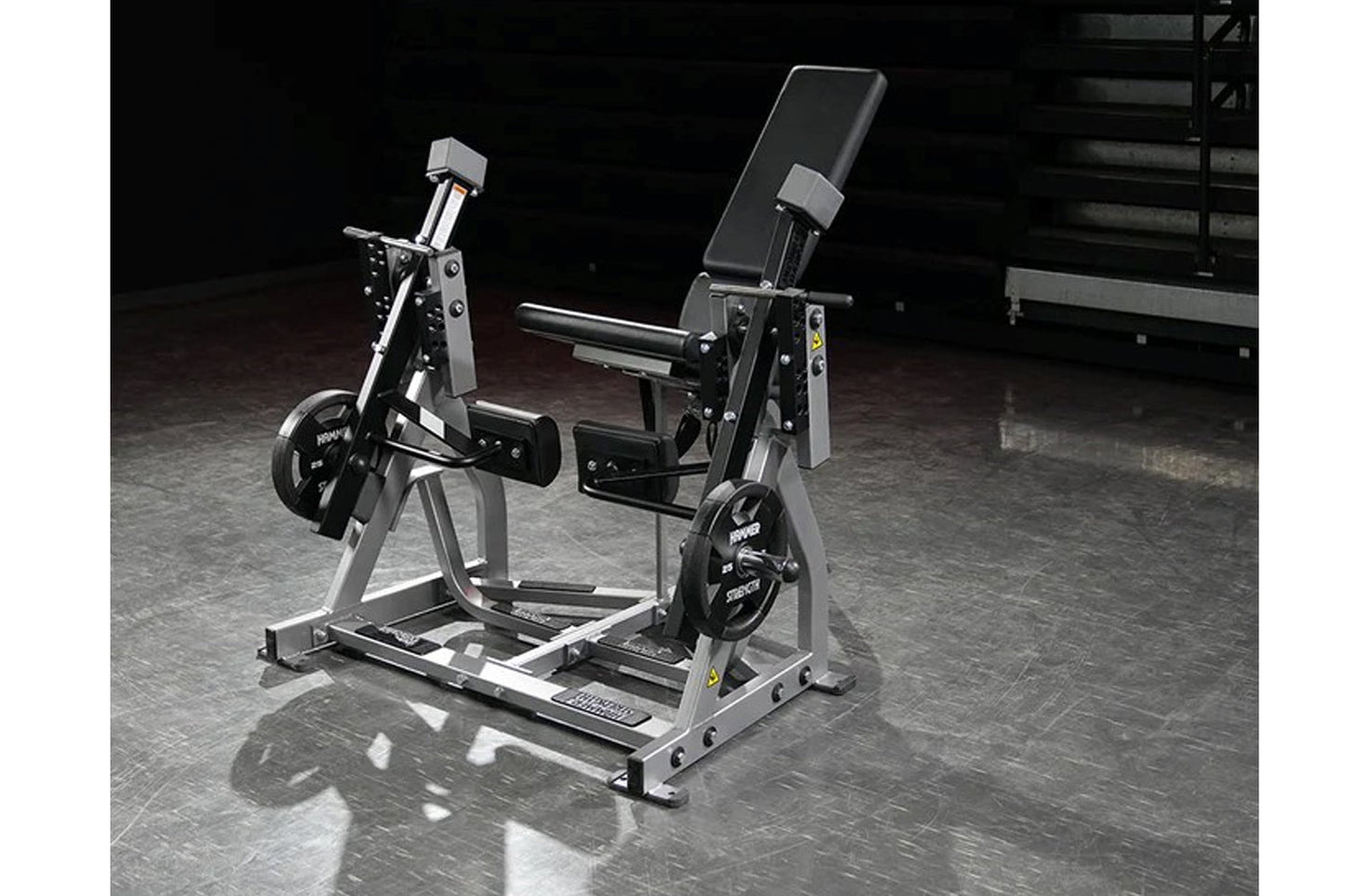 Hammer Strength plate-loaded iso-lateral leg extension machine with gray frame, black seat, and dual weight plate holders on 