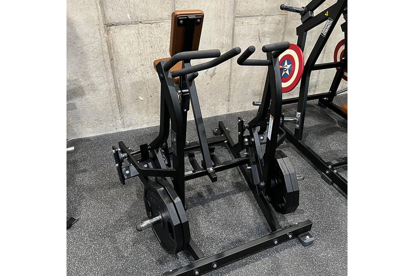 Hammer Strength black plate-loaded iso lateral row machine with padded handles and weight plates, in gym setting