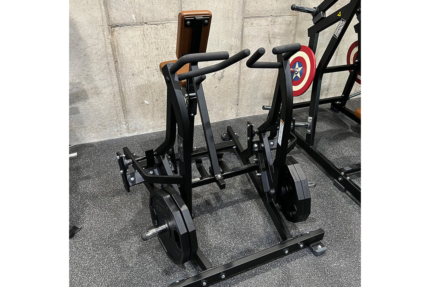 Hammer Strength black plate-loaded iso lateral row machine with padded handles and weight plates, in gym setting