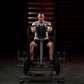 Man using black plate-loaded iso lateral row machine with gray seat, gripping handles during workout on dark gym floor