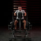 Man using black Hammer Strength plate-loaded iso lateral row machine, wearing gray t-shirt and black shorts in gym setting