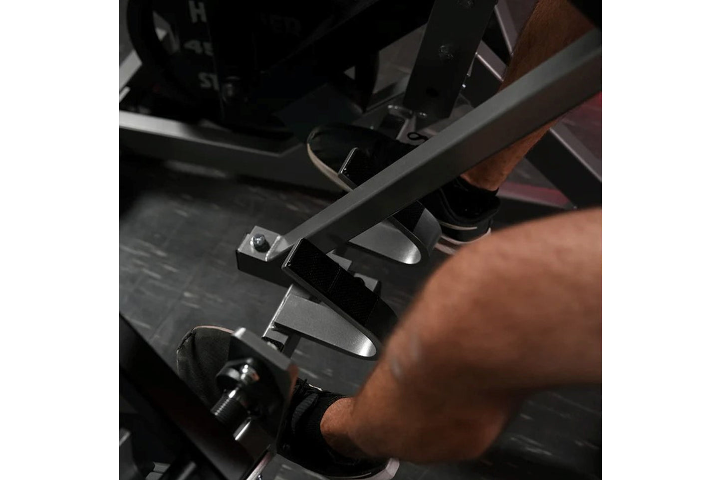 Person using black plate-loaded iso lateral row machine with metal frame and handles