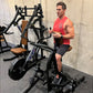 Man in red tank top using black and tan plate-loaded iso lateral row machine in gym setting