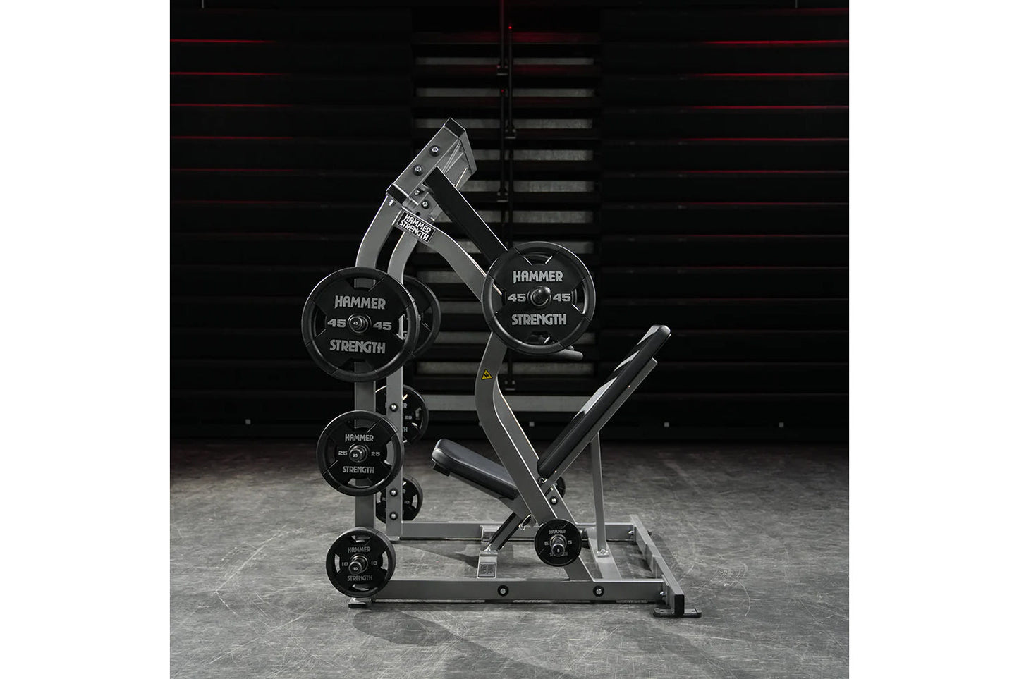 Hammer Strength plate-loaded iso-lateral shoulder press machine with black weight plates and gray frame in gym setting