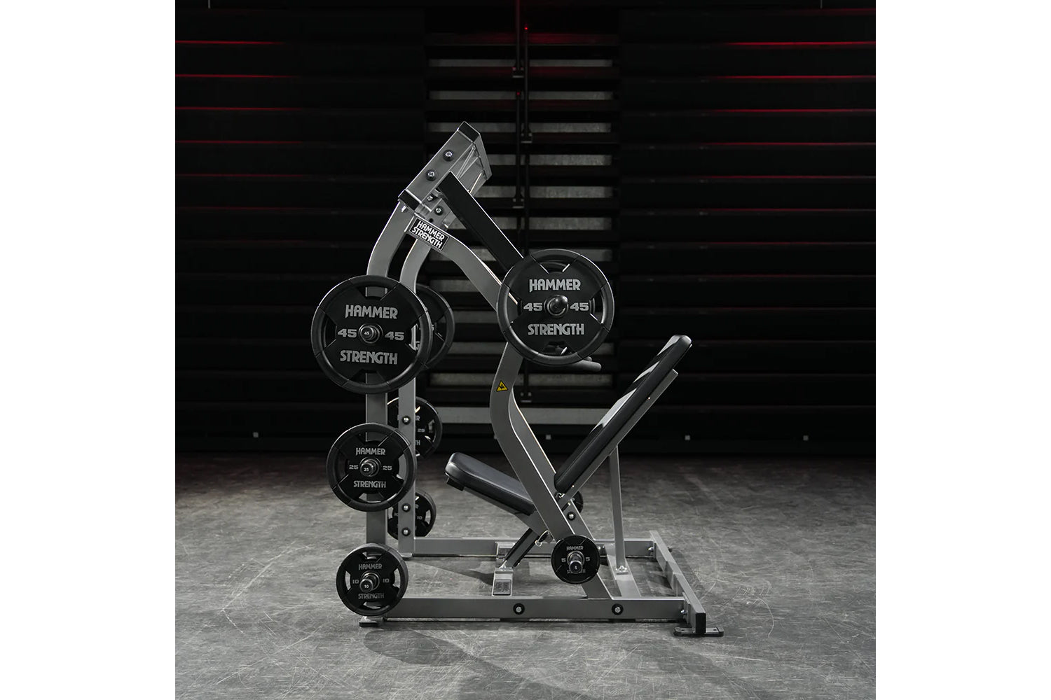 Hammer Strength plate-loaded iso-lateral shoulder press machine with black weight plates and gray frame in gym setting