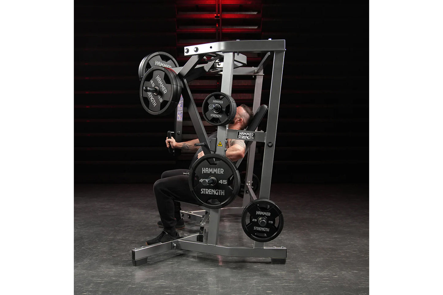Hammer Strength plate-loaded iso-lateral wide chest machine with black weight plates, used by male model in gym setting