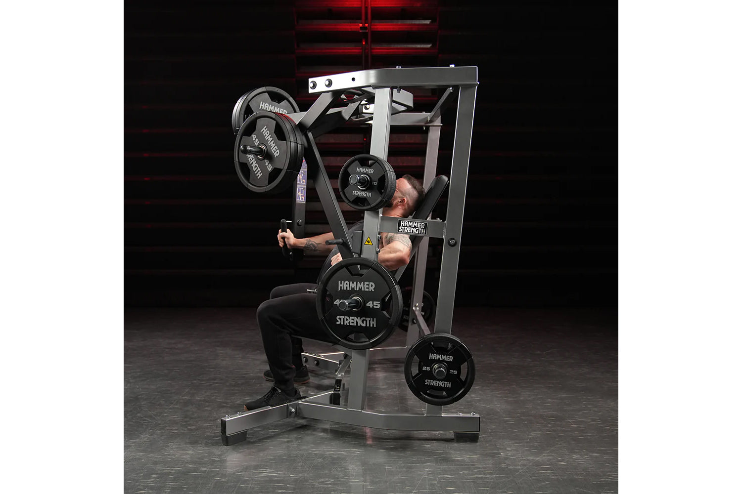 Hammer Strength plate-loaded iso-lateral wide chest machine with black weight plates, used by male model in gym setting