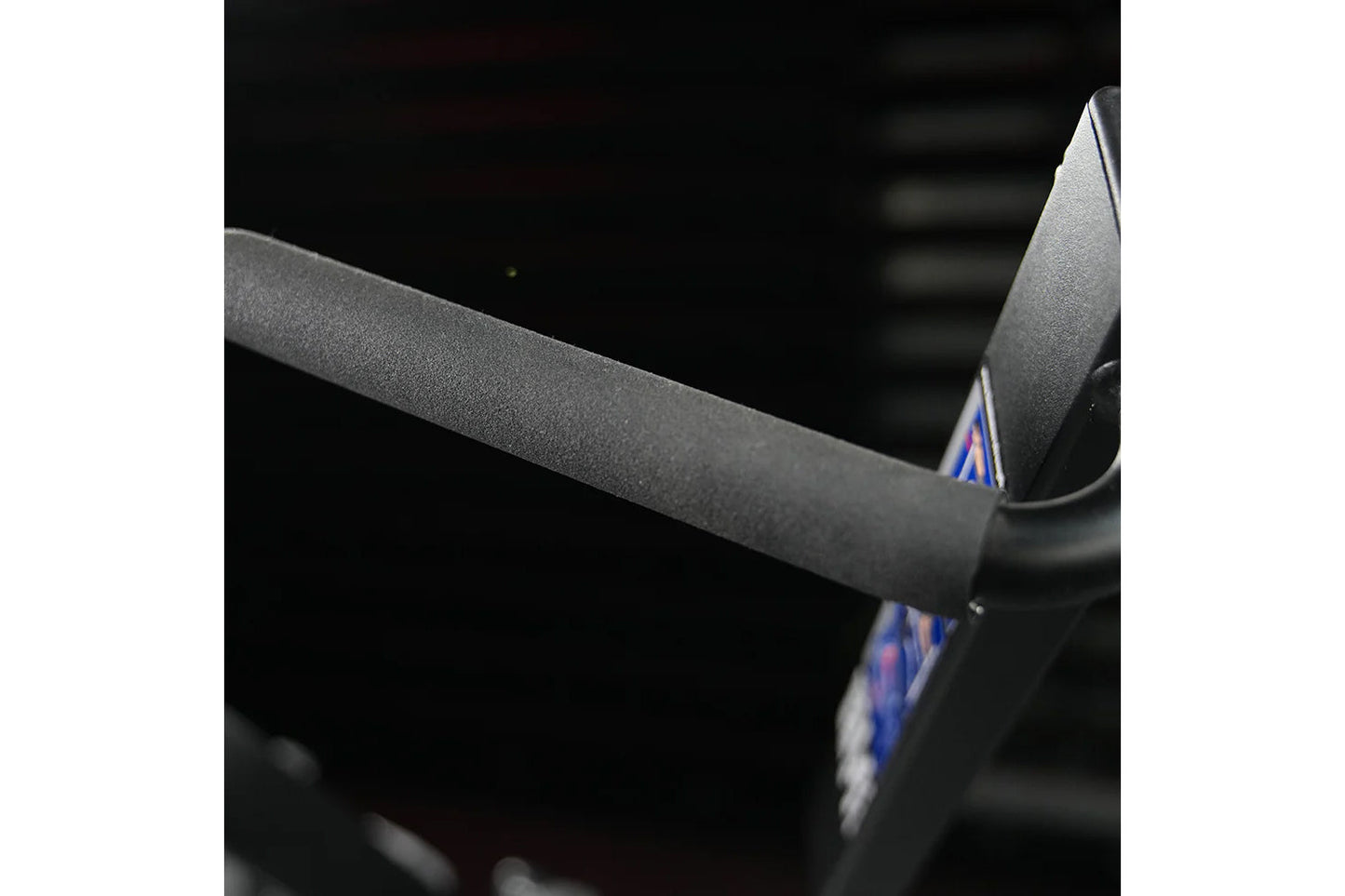 Gray fabric seat and armrest detail of Hammer Strength plate-loaded iso-lateral wide pulldown machine, close-up view
