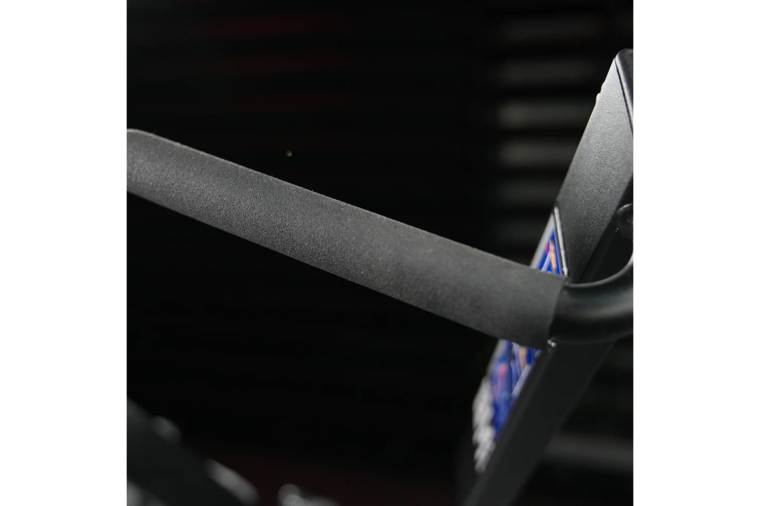 Gray fabric seat and armrest detail of Hammer Strength plate-loaded iso-lateral wide pulldown machine, close-up view