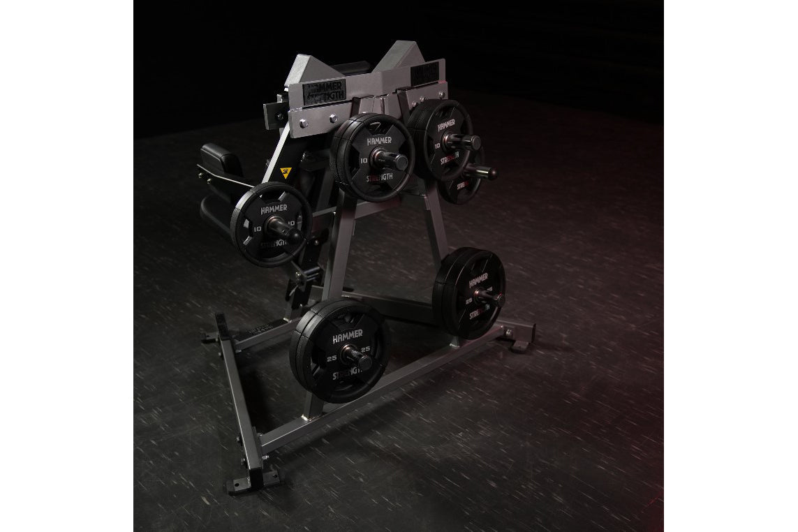Hammer Strength plate-loaded lateral raise machine with gray frame and black weight plates on dark background