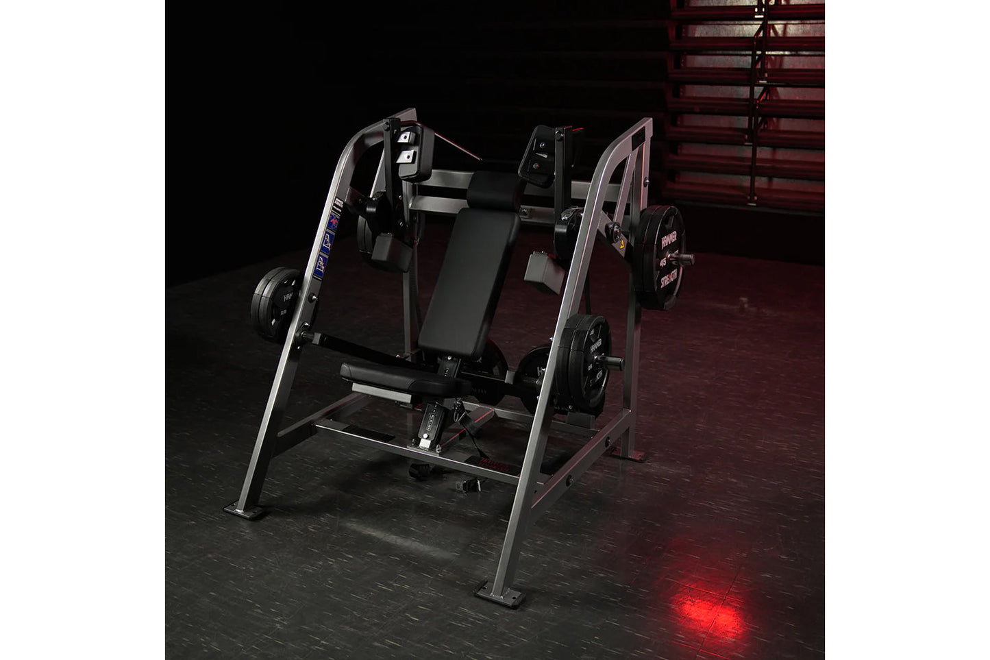 Hammer Strength plate-loaded pullover machine with black seat, silver frame, and weight plates on dark gym floor