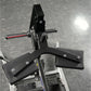 Hammer Strength plate-loaded seated calf raise machine with black padded foot platform and metal frame on gym floor