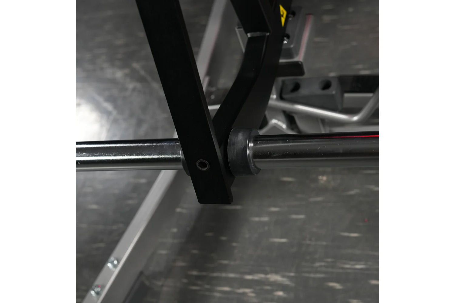 Black and chrome plate-loaded calf raise machine detail showing foot plate and adjustment pin connection