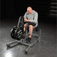 Man using Hammer Strength plate-loaded seated calf raise machine with black weight plates in gym setting