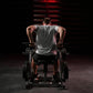 Man wearing gray sleeveless tank top using plate-loaded seated dip machine in gym setting with red lighting