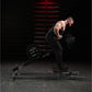 Muscular man performing bent-over row exercise on black Hammer Strength plate-loaded T-bar machine in gym setting