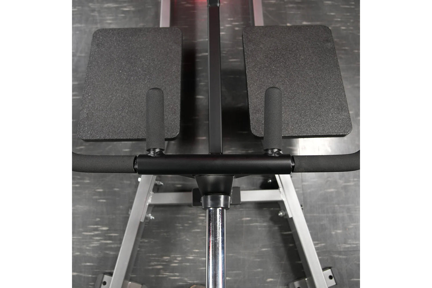 Hammer Strength plate-loaded T-bar row machine with gray padded foot plates, black handlebar, and chrome base on textured gra