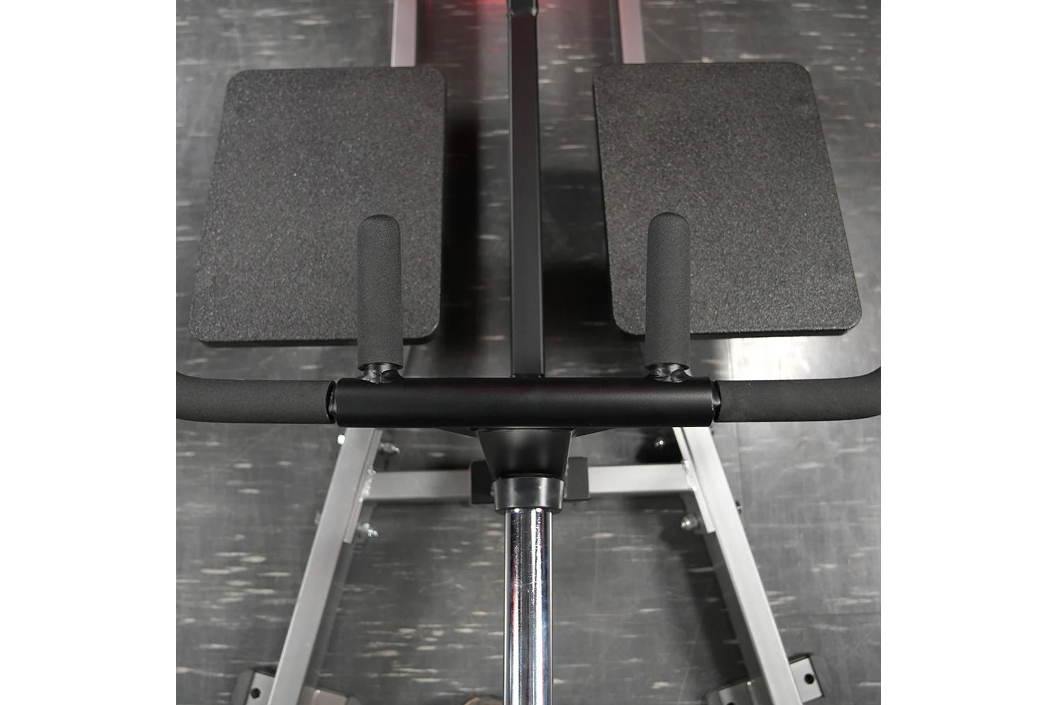 Hammer Strength plate-loaded T-bar row machine with gray padded foot plates, black handlebar, and chrome base on textured gra