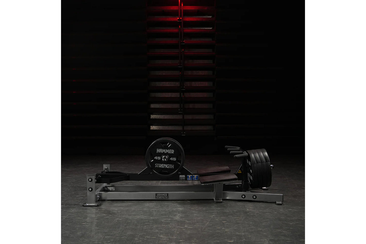 Hammer Strength plate-loaded T-bar row machine with black frame and weighted plates on concrete gym floor
