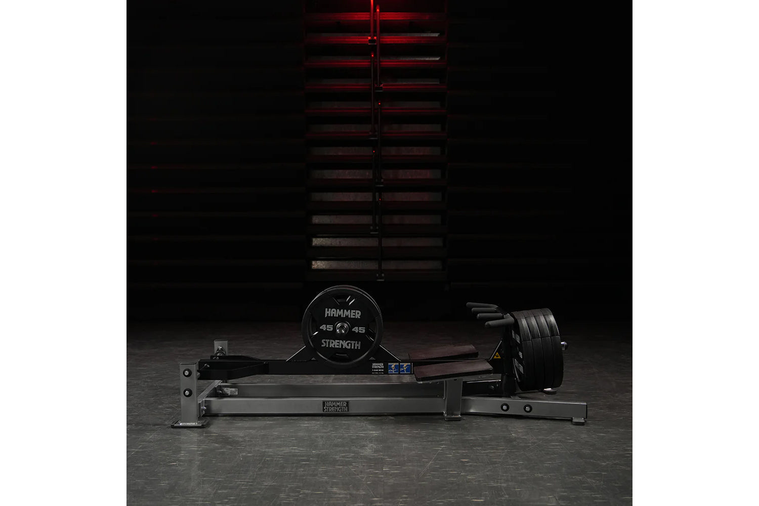Hammer Strength plate-loaded T-bar row machine with black frame and weighted plates on concrete gym floor