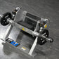 Hammer Strength plate-loaded tibia dorsi flexion bench machine with black weight plates and gray frame on dark background