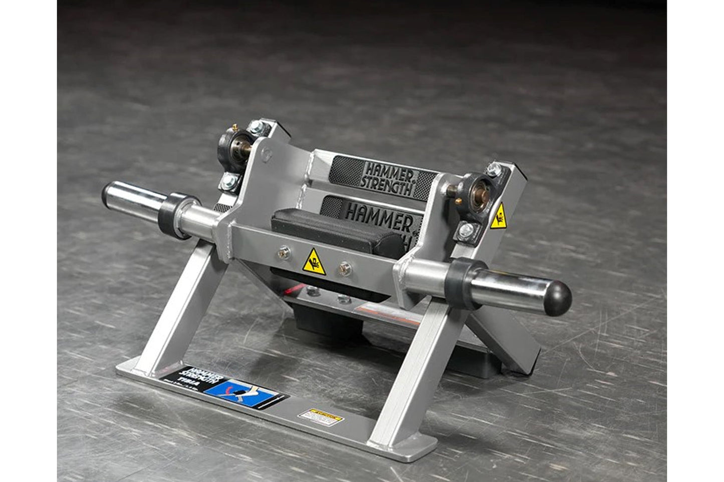 Hammer Strength plate-loaded tibia dorsi flexion bench machine with gray and black frame, metallic cylinders, and yellow warn