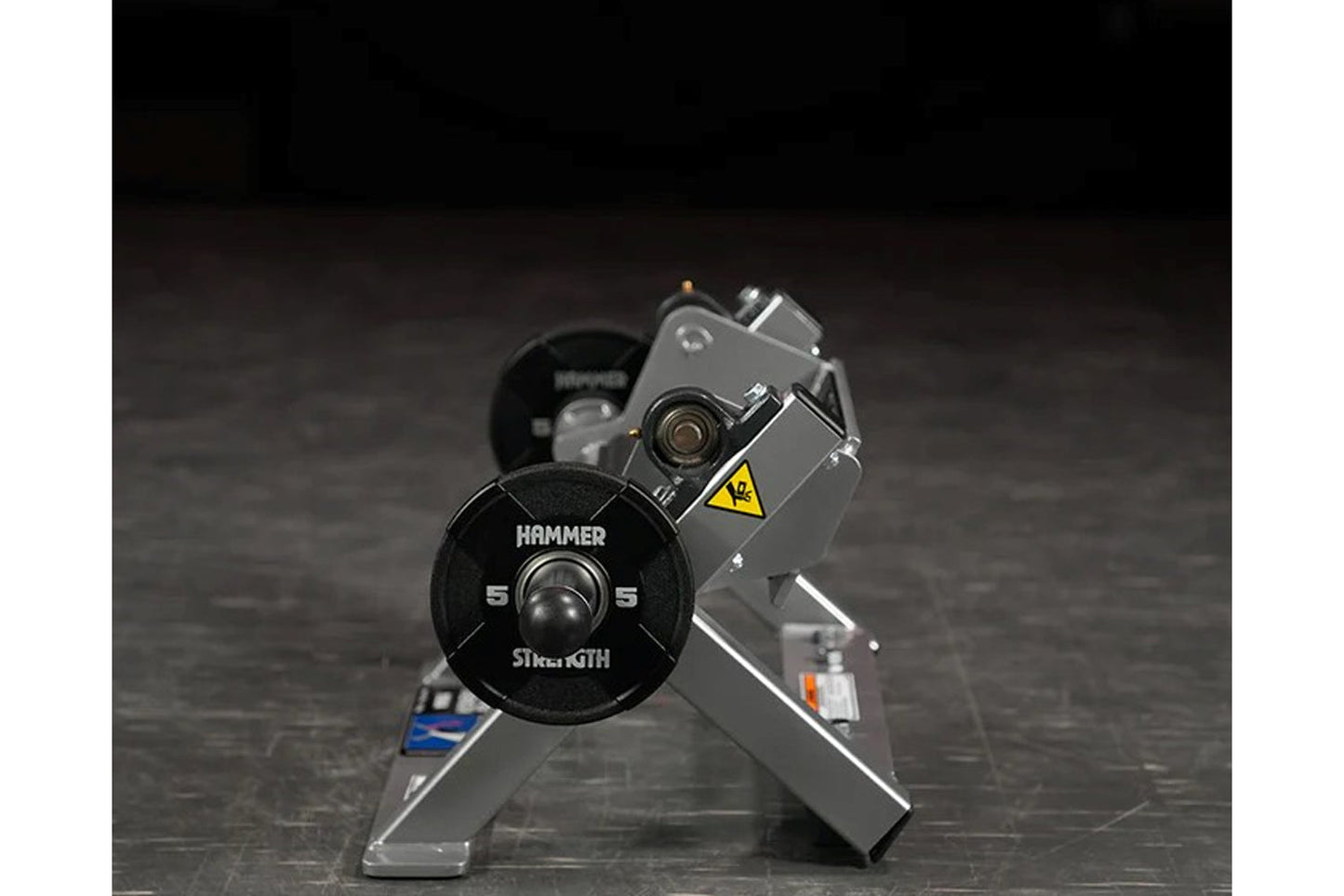 Hammer Strength black plate-loaded tibia dorsi flexion bench machine with weight plate, displayed on dark textured surface