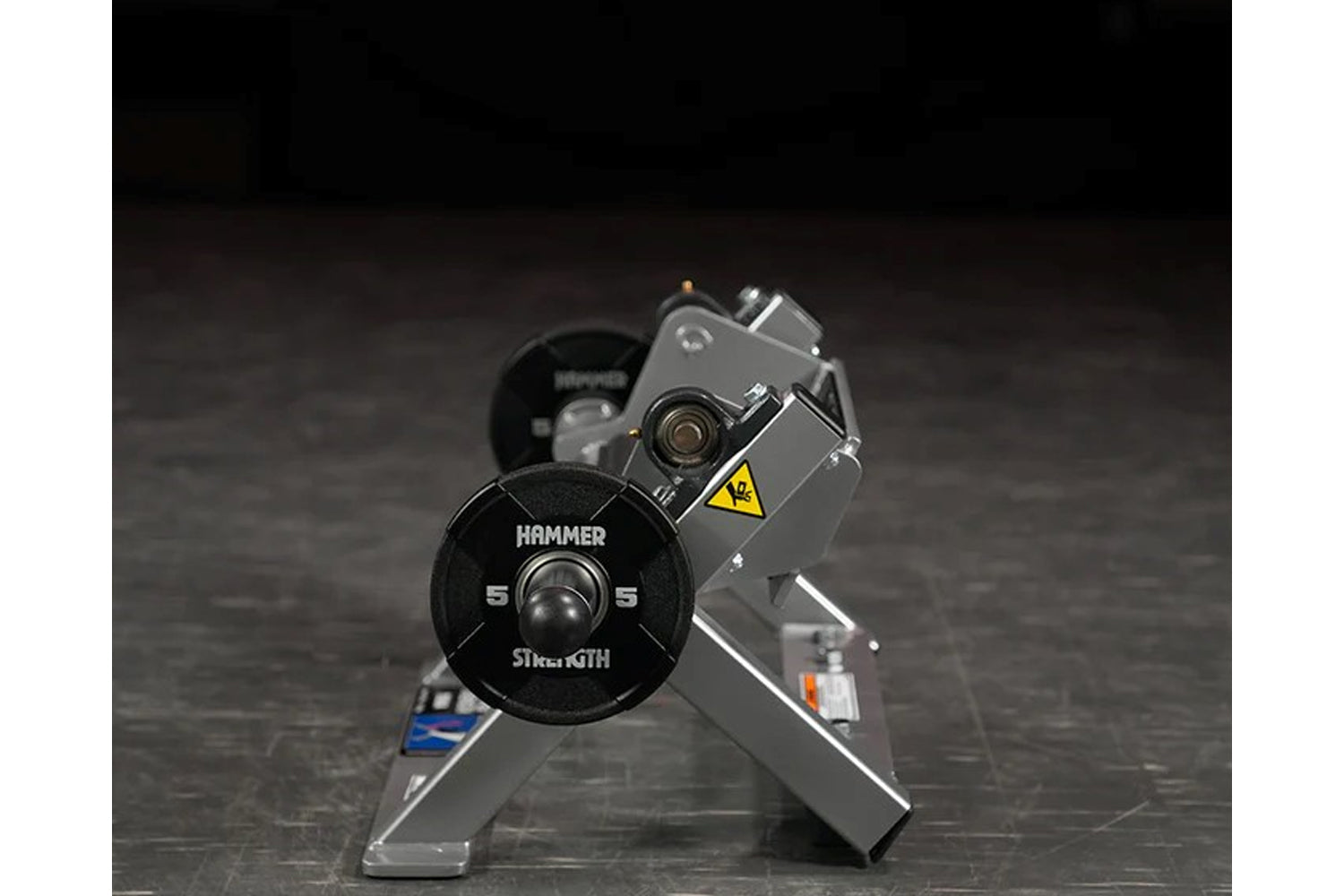 Hammer Strength black plate-loaded tibia dorsi flexion bench machine with weight plate, displayed on dark textured surface
