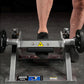 Man's feet on black footplate of Hammer Strength plate-loaded tibia dorsi flexion machine with silver frame and black weight 