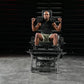 Man performing leg exercise on black plate-loaded V-squat machine with dumbbells, gym setting