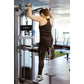 Woman performing assisted dip exercise on Hammer Strength Select machine in gym setting, wearing black sports bra and legging