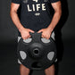Man wearing black graphic t-shirt holding black Olympic weight plate with gray grip handles, front view