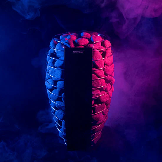Black cylindrical sauna heater surrounded by neon blue and pink ribbed stone modules against dark purple background