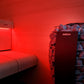 Harvia Spirit Electric Sauna Heater Package with red sauna room interior, wooden bench, and heated stones in cylindrical hold