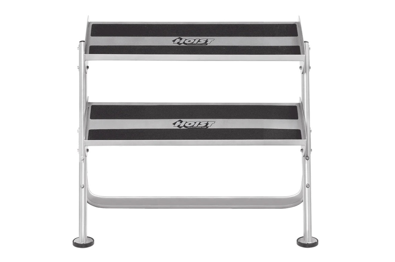Two-tier horizontal dumbbell rack with silver aluminum frame and black grip surfaces, branded "Hoist", on white background