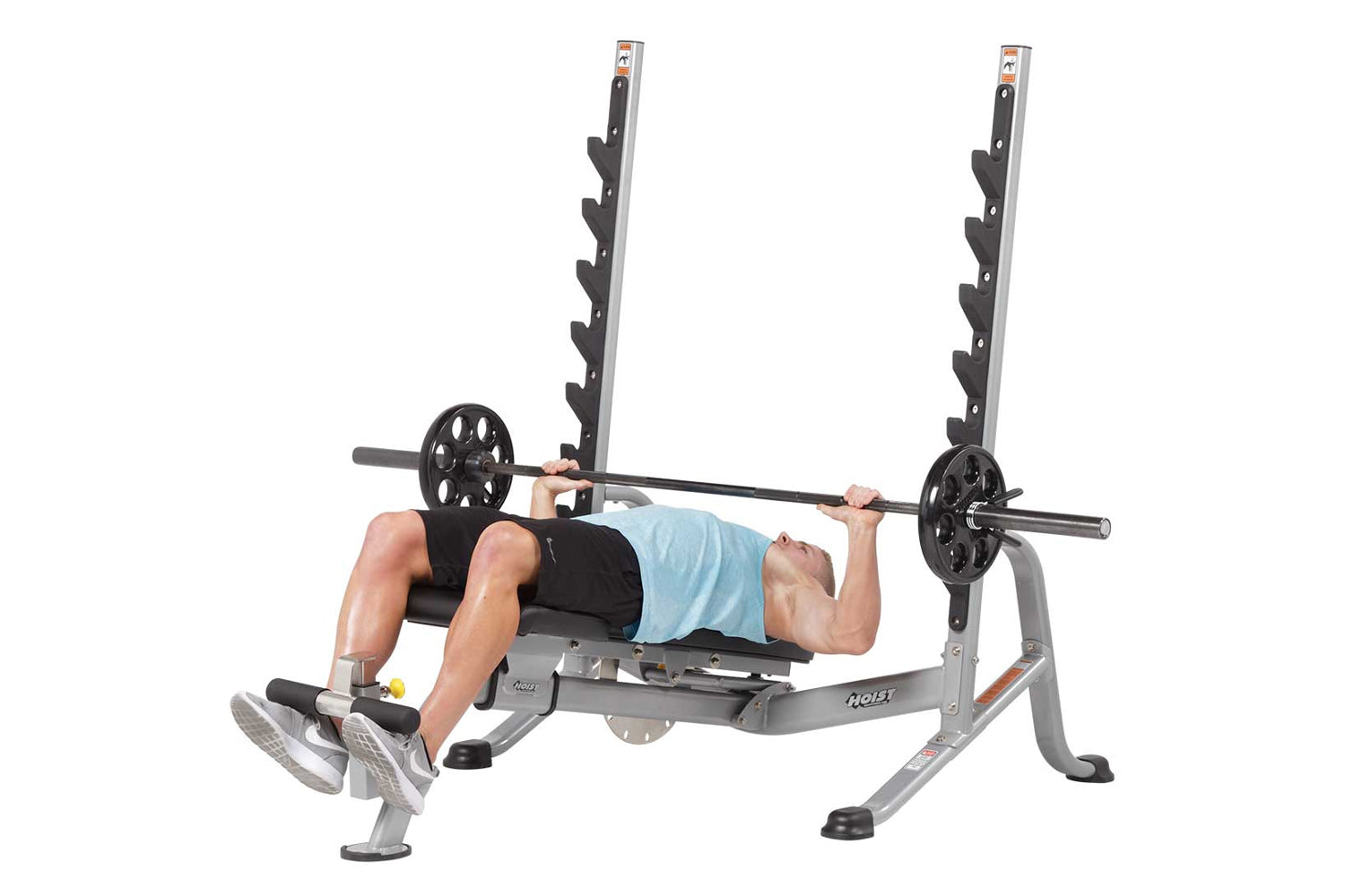 Hoist 7-Position Olympic Bench Press with dual black weight pegs, gray frame, and black upholstered bench, demonstrated by ma