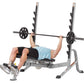 Hoist 7-Position Olympic Bench Press with black weight plates and bar, shown with model performing chest press exercise on gr