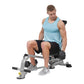 Male model wearing light blue tank top and black shorts using silver and black weight bench with adjustable seat and leg exte