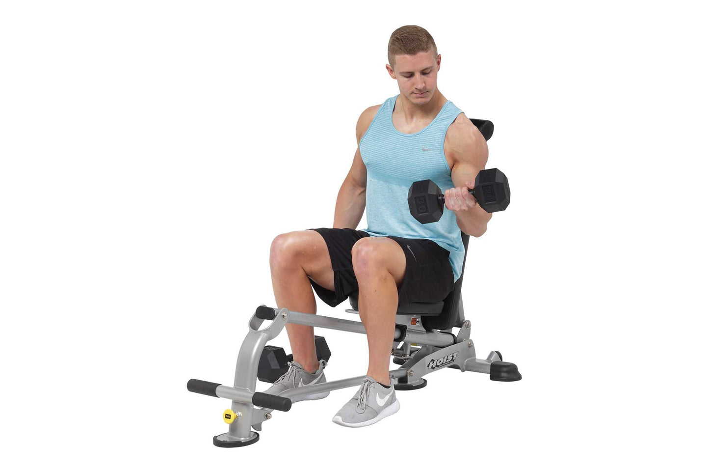 Man in light blue tank top and black shorts performing dumbbell exercise on gray and black folding weight bench