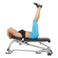 Model performing leg raise exercise on Hoist 7-Position Folding Fid Bench, wearing blue leggings and black sports bra with bl