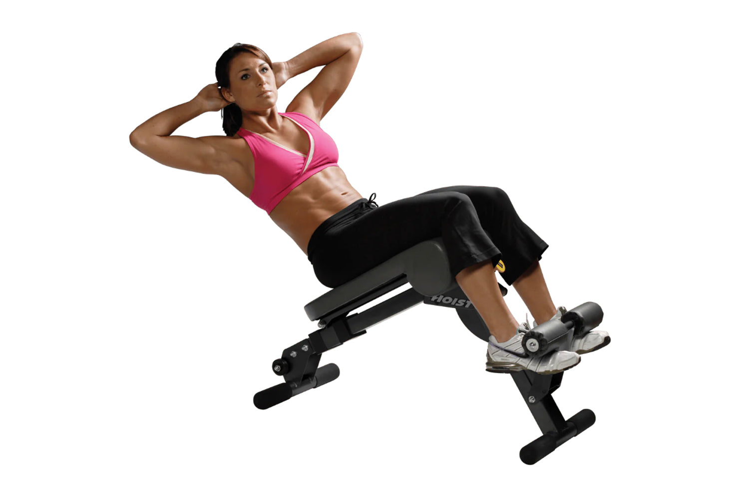 Woman in pink sports bra and black shorts performing abdominal crunch on black Hoist ab and back hyperextension bench against