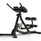 Black Hoist Roman hyperextension bench with adjustable backrest, padded leg hold-down bar, and dual grip handles on white bac
