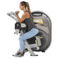 Woman using Hoist Biceps Curl machine with gray and black frame, demonstrating seated exercise position on white background