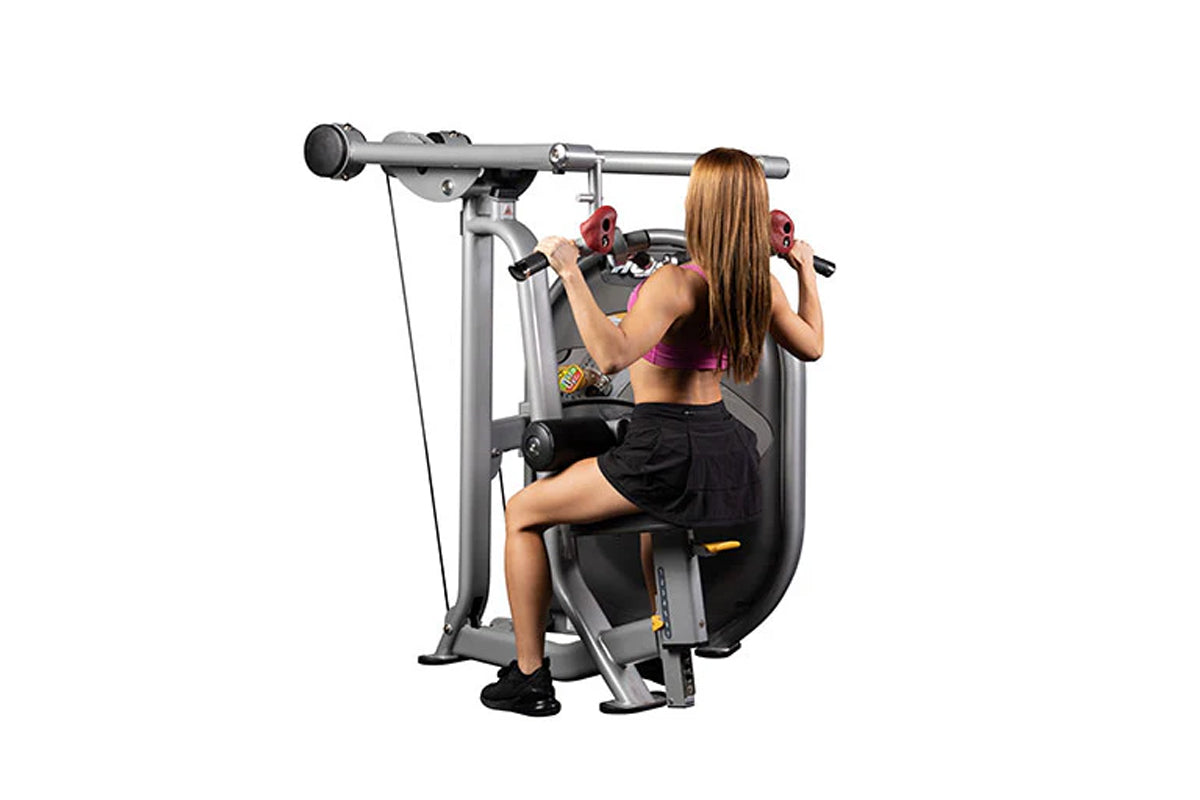Woman using gray and black Hoist lat pulldown machine with red handles, seated on black padded seat performing exercise