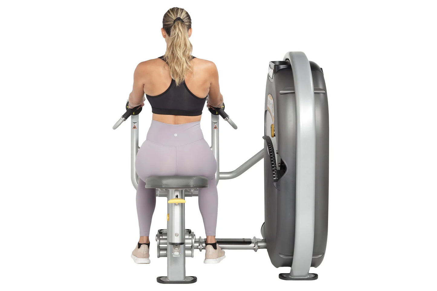 Woman using Hoist Mid Row machine, viewed from behind, wearing black sports bra and lavender leggings