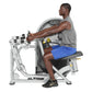 Man using Hoist Mid Row exercise machine with gray and black frame, seated position on black seat pad with blue shorts and gr