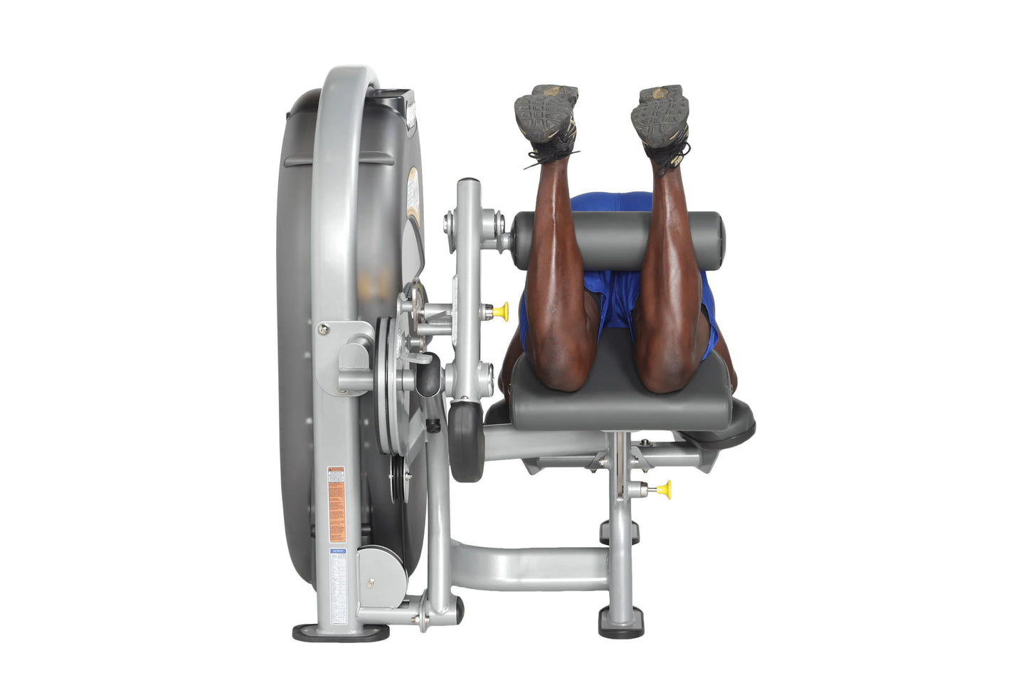 Hoist Standing Prone Leg Curl machine with silver frame, blue seat pad, and leg extension attachment, shown from side angle