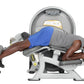 Man using Hoist Standing Prone Leg Curl machine, wearing blue shorts and gray shirt, on white background