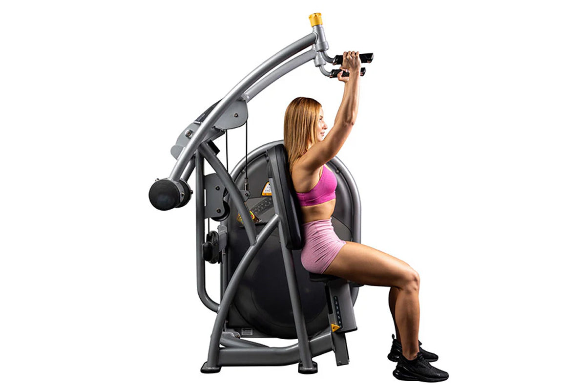 Hoist Club Line Shoulder Press machine with gray and black frame, woman in pink sports bra and shorts using equipment on whit